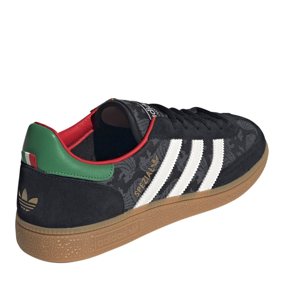 Black low-top sneaker side view with white stripes, green and red collar accents