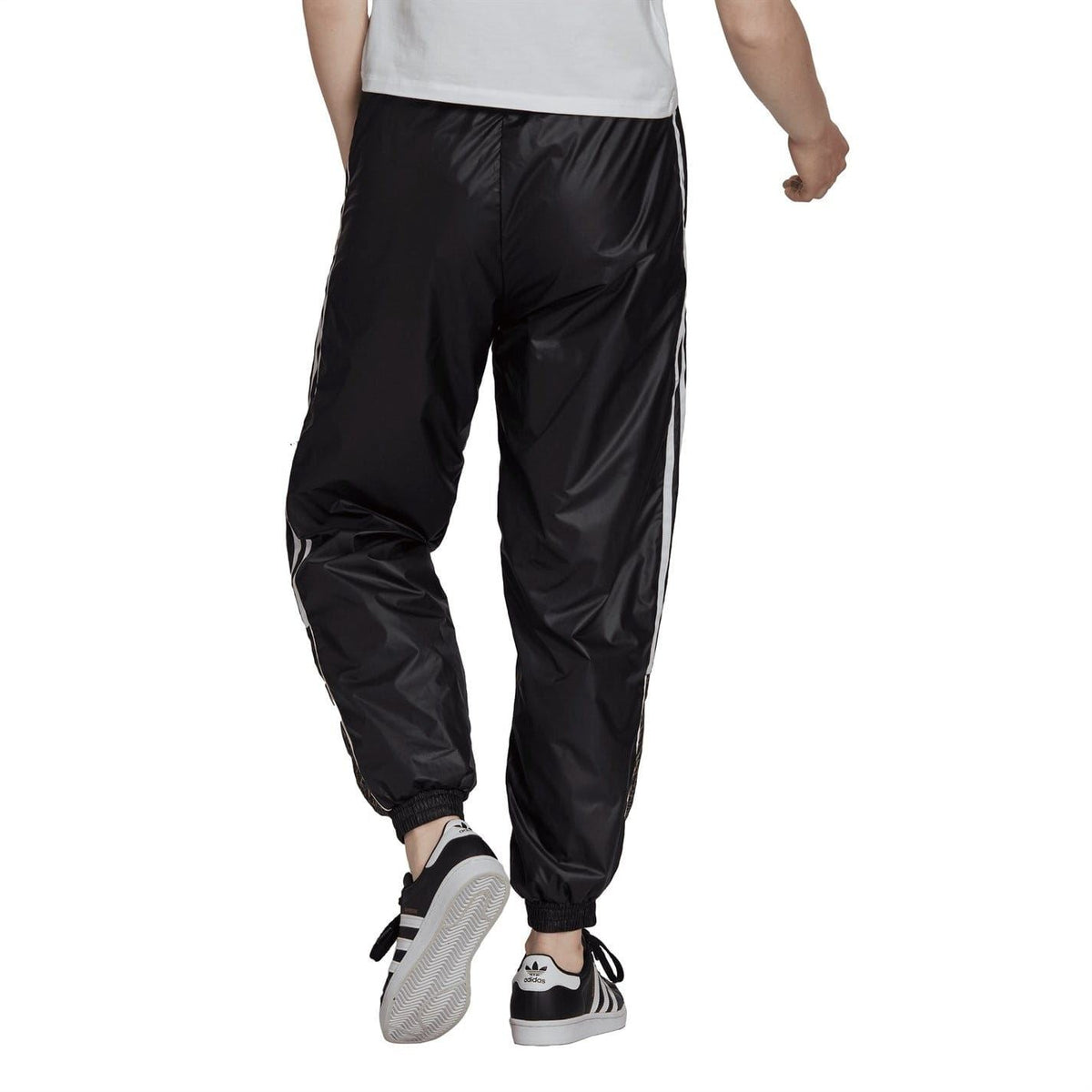 Black track sweatpants with white side stripes and tapered jogger fit, elastic cuffs