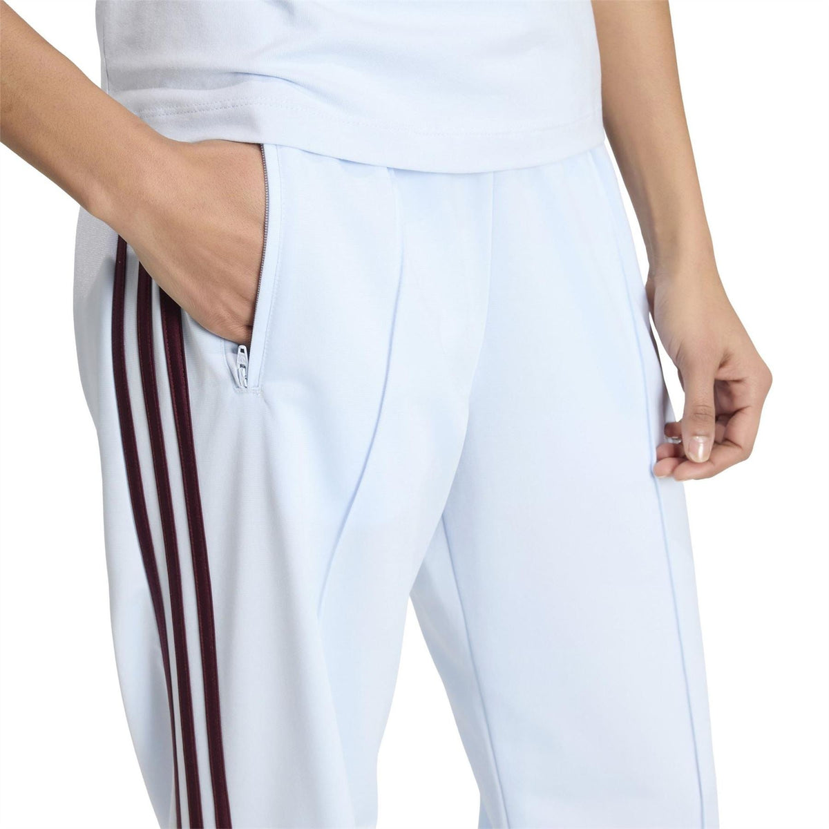 Womens white joggers with maroon striped seam and zip pocket detail near hip