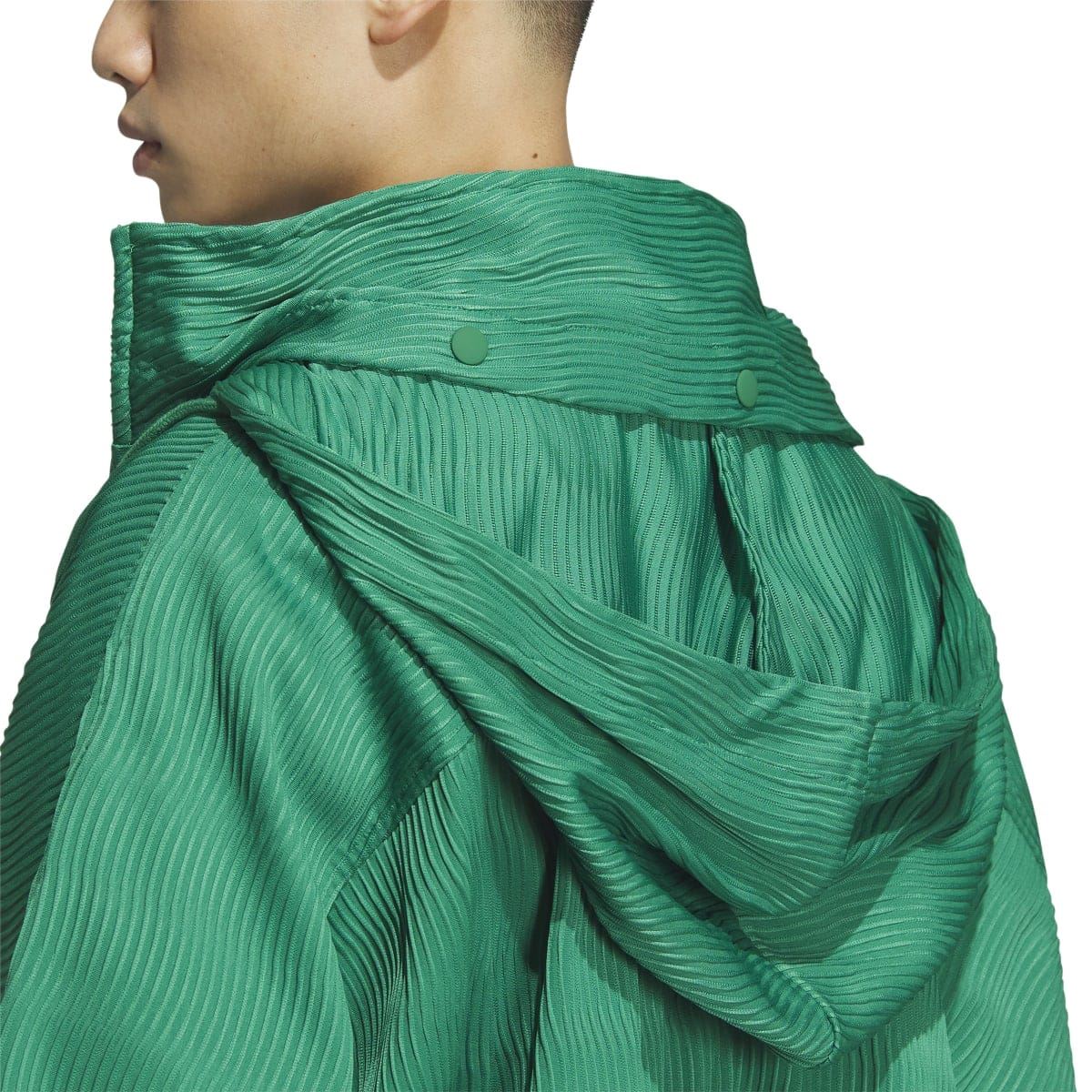 Green hooded jacket close-up with draped hood and ribbed knit texture