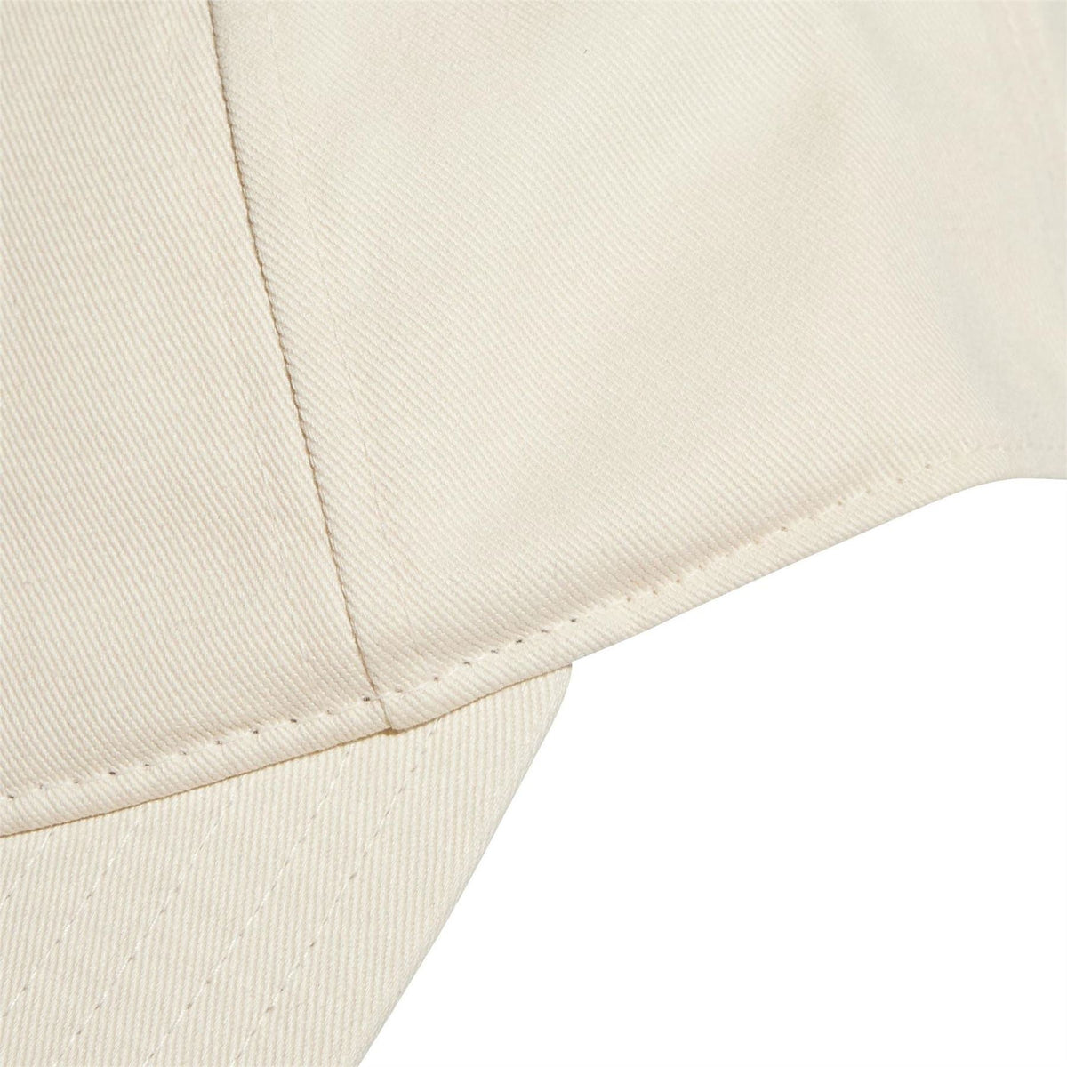 Close-up light beige dad cap brim with visible stitching and curved edge