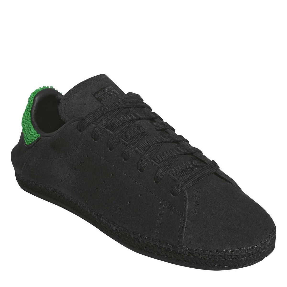 Black trainers with green heel detail, lace-up upper and suede-like finish
