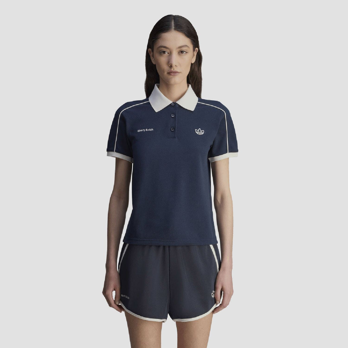 Navy short-sleeve polo shirt with white-trim shoulders and chest crest logo