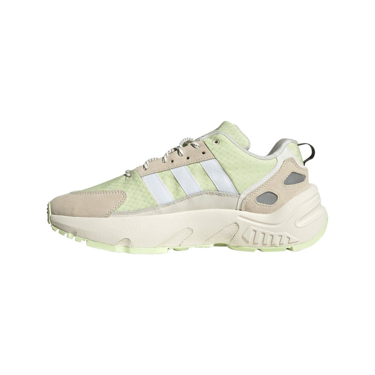 Off white and light green low-top trainers with side stripes, lace eyelets, and chunky sole