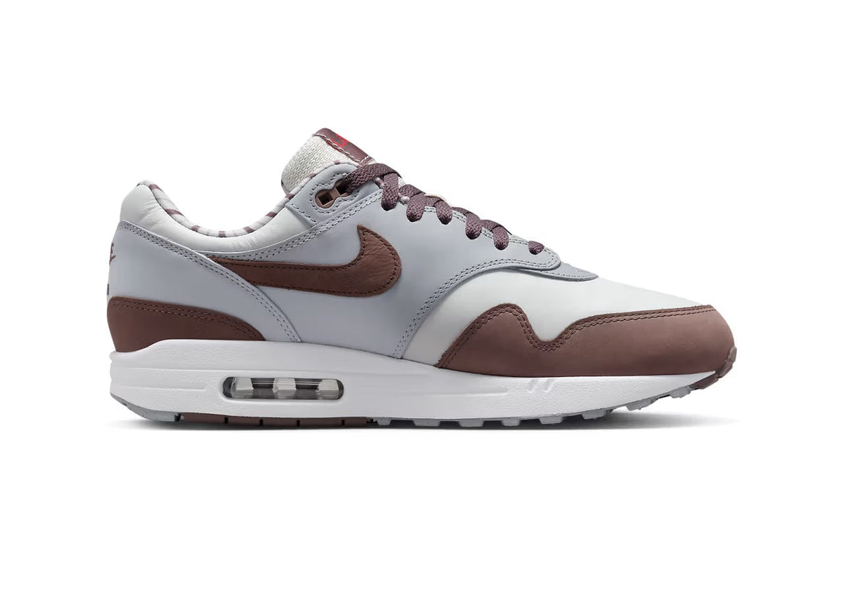 Low-top sneakers, side view: white leather with brown mudguards and Nike swoosh