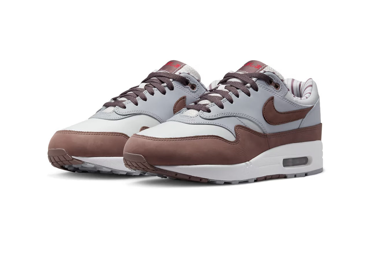 Pair of low-top sneakers in white and brown with visible Air unit and lace-up front