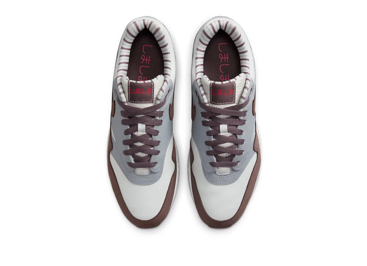 Pair of lace-up sneakers with white uppers and brown toe caps; showing insides