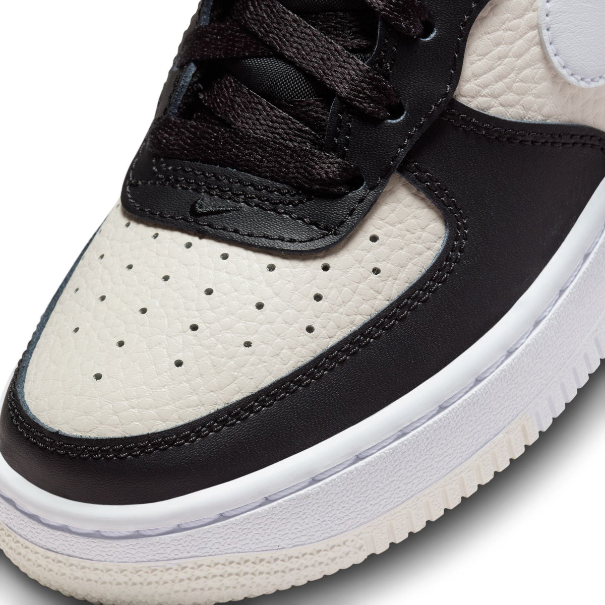 Nike Air Force 1 sneaker upper close-up with black toe panel and white side