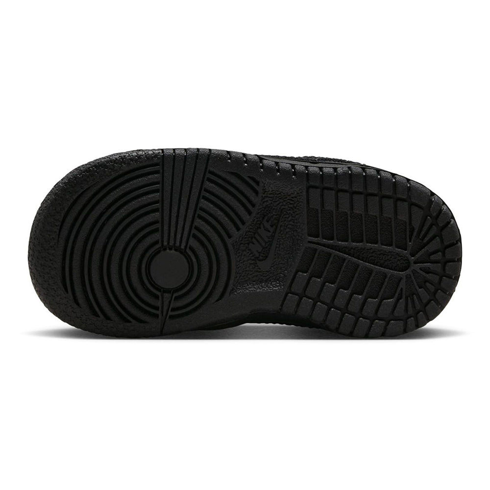 Kids' black Nike Dunk Low outsole with tread and circular traction pattern