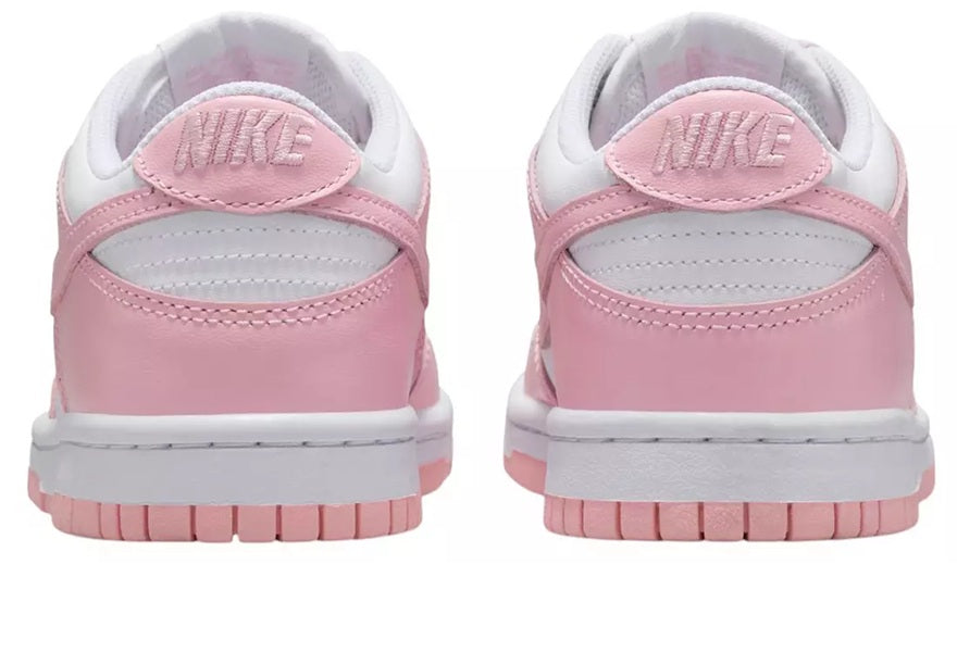 Big kids Nike Dunk Low sneakers with pink heel panels and NIKE logo on back