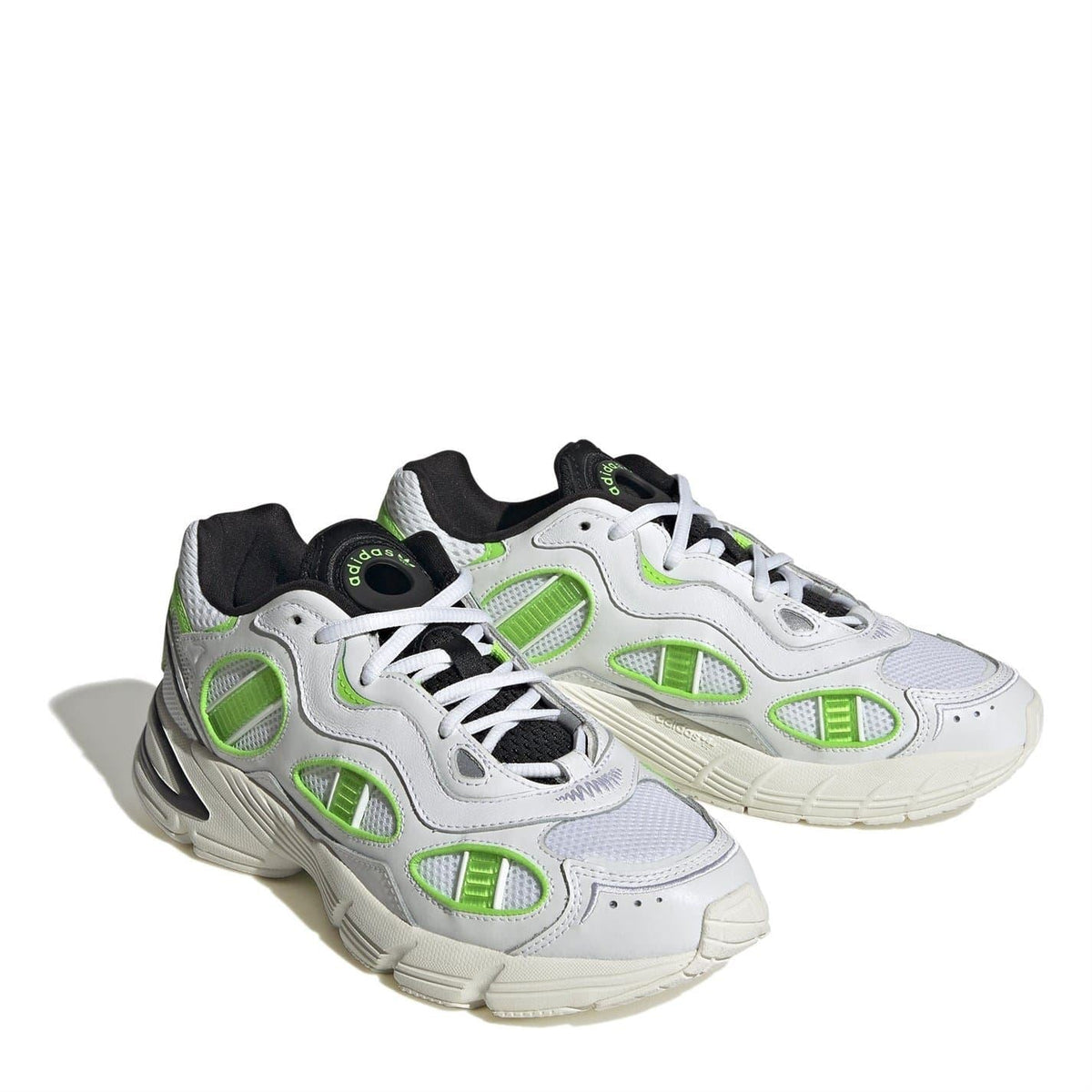 Two-tone white sneakers with neon green paneling, black collar lining, and thick sole
