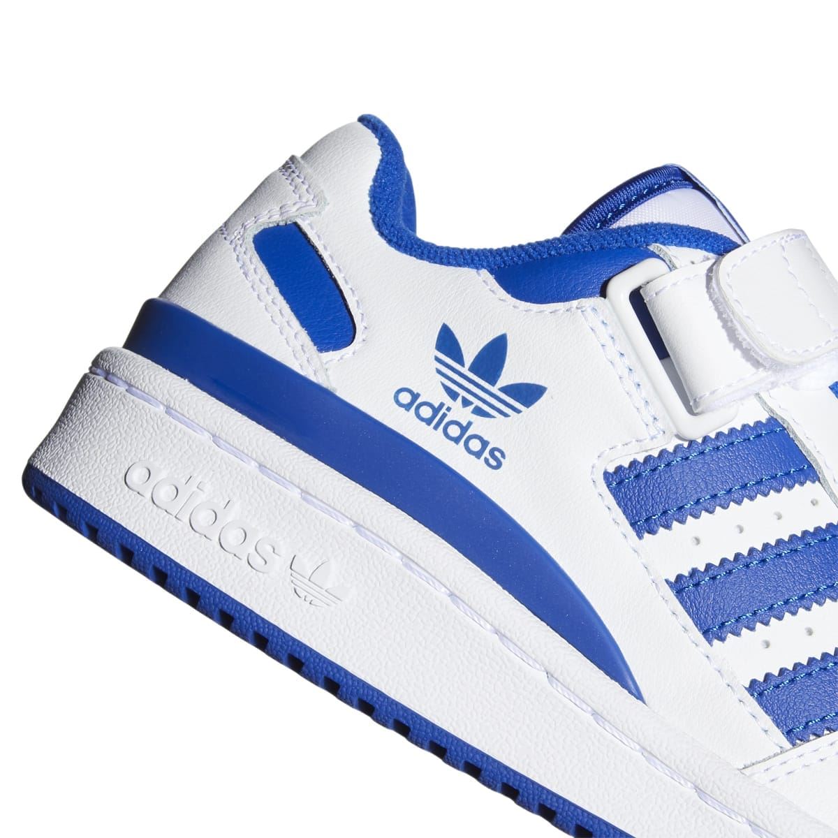Close-up of kids white and blue low-top sneaker side with Adidas logo