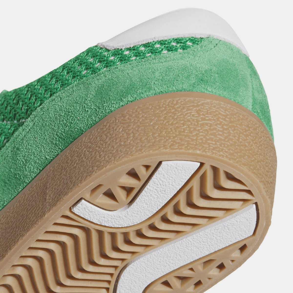 Close-up of green trainer outsole with gum tread pattern and adidas detail