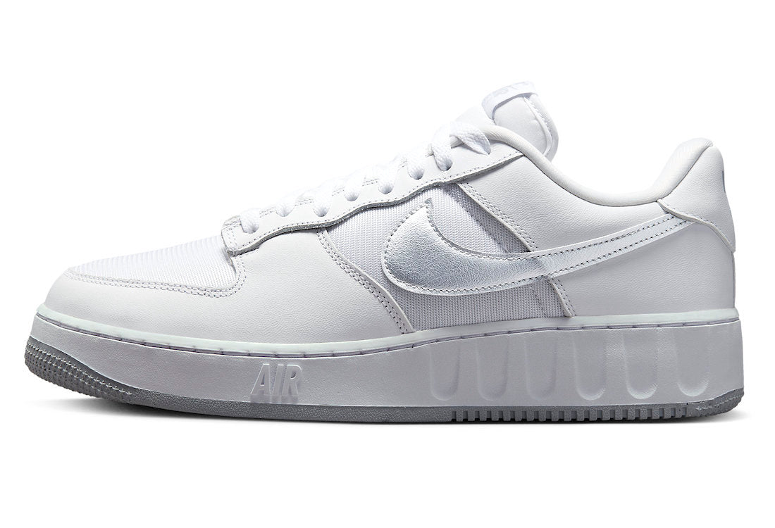 White low-top sneakers with silver Nike Swoosh and lace-up design