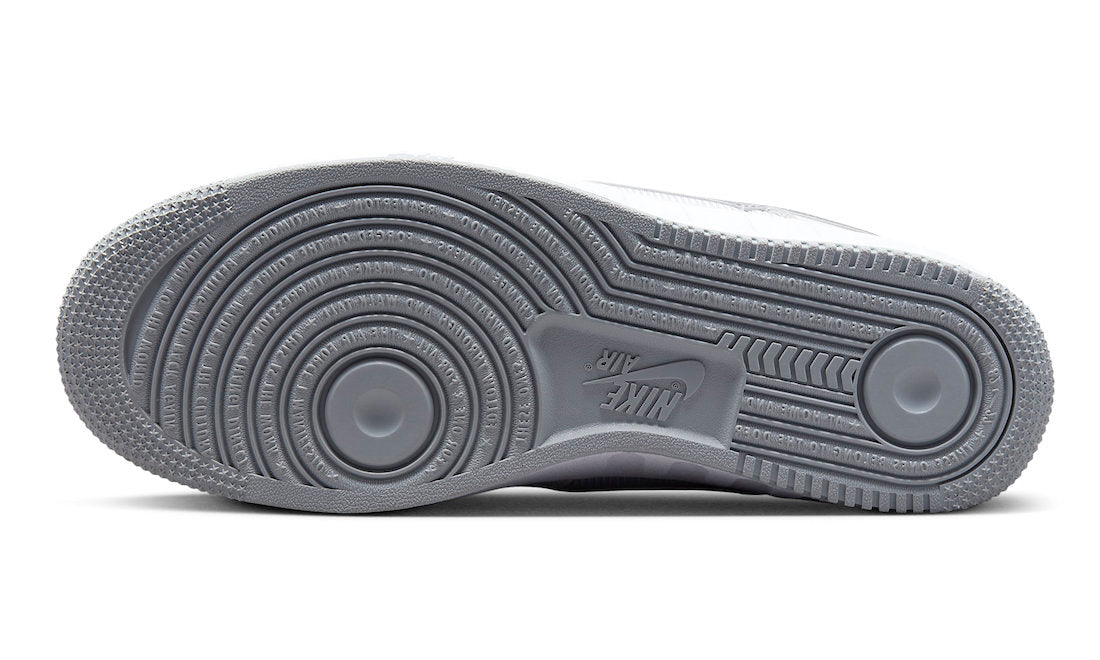 Grey textured rubber outsole with circular traction pods and herringbone tread
