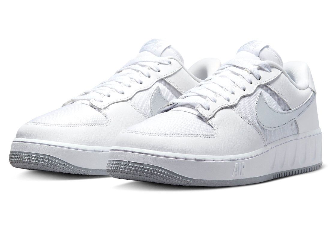 Pair of white low-top sneakers with silver Swoosh and textured rubber sole