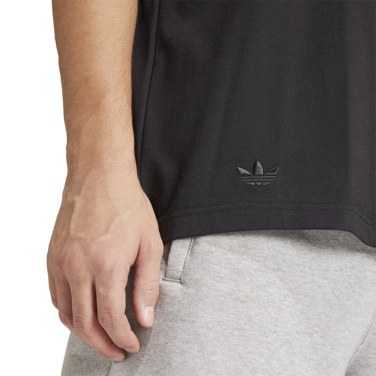 Black T-shirt hem with small adidas trefoil logo detail