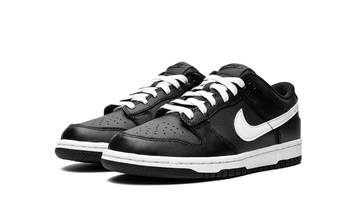 Kids' black low-top sneakers with white Nike swoosh and lace-up front