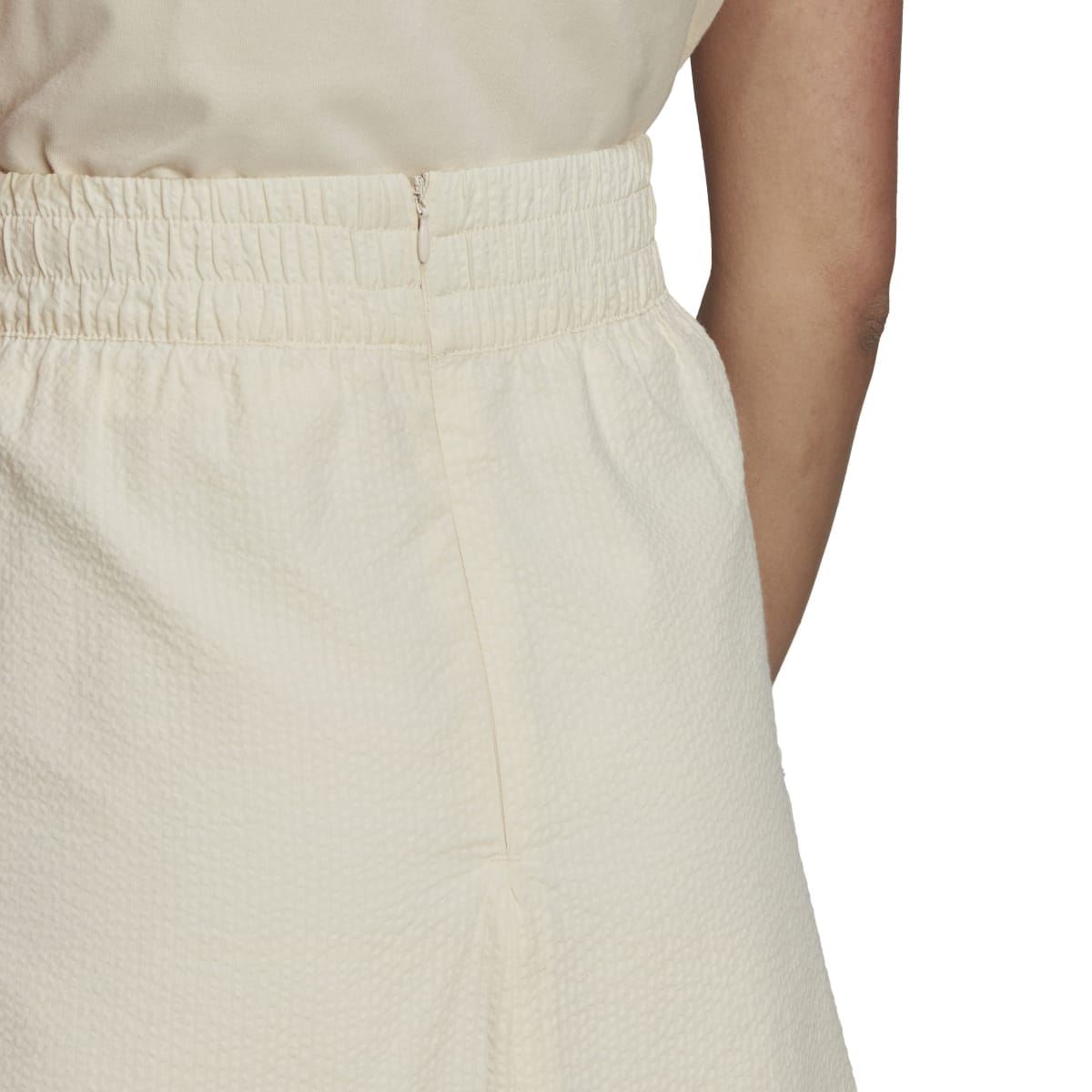 Adidas Originals Adicolor Classics poplin skirt with a high-waisted fit and vibrant color, worn with casual styling.