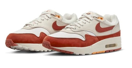 Women's Nike Air Max 1 LX sneakers, front view with sail laces, orange toe and Air window