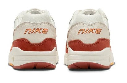 Women's Nike Air Max 1 LX sneakers back view with orange heel panel and Nike branding