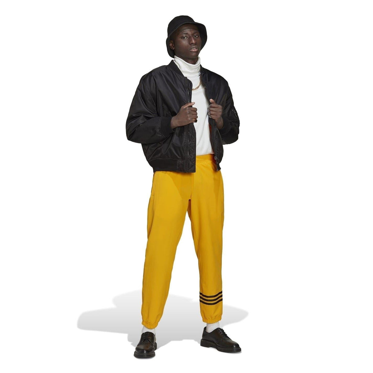 Gold adidas joggers with black striped ankle bands and elastic waistband