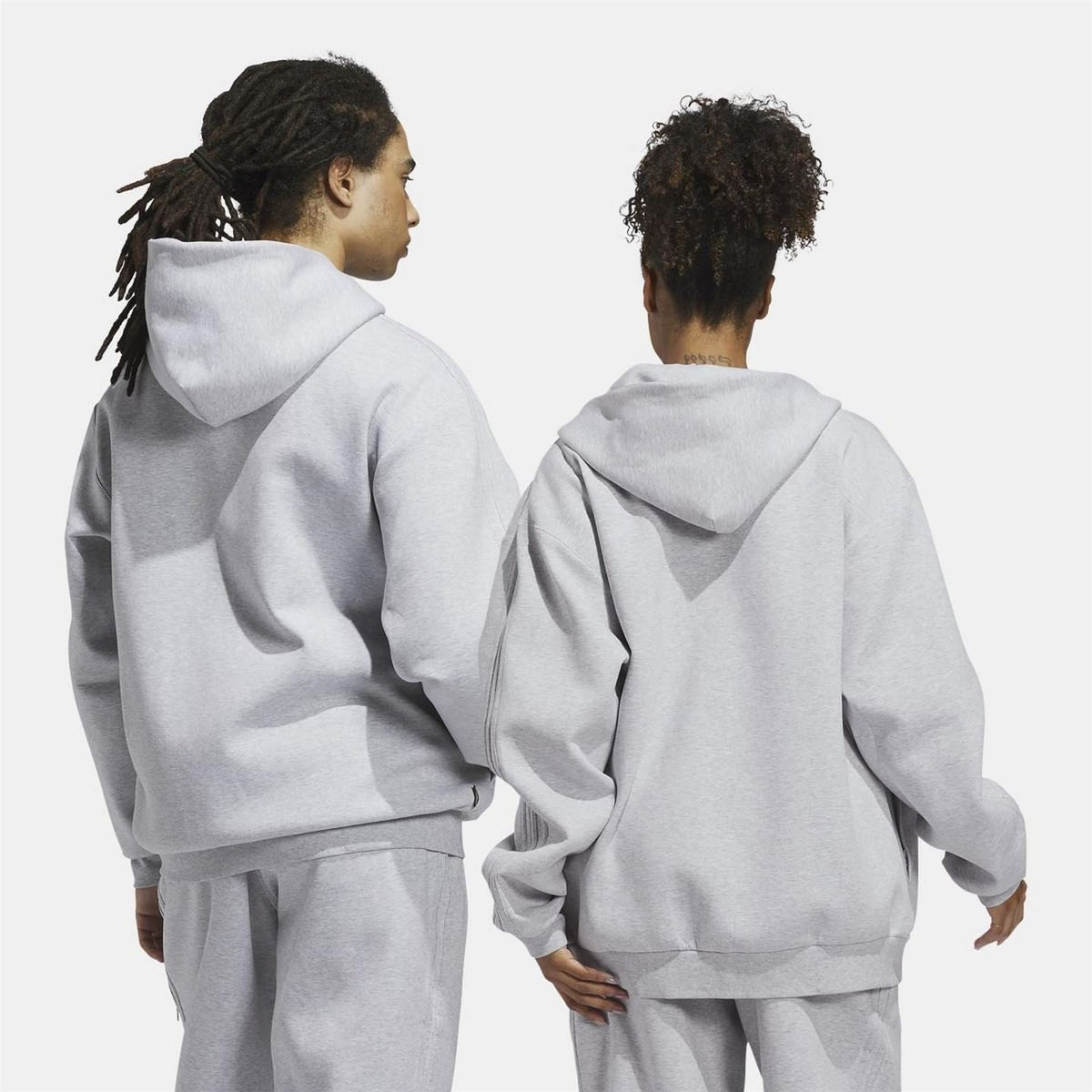 Grey zip-up fleece hoodie on model, rear view with hood and ribbed cuffs