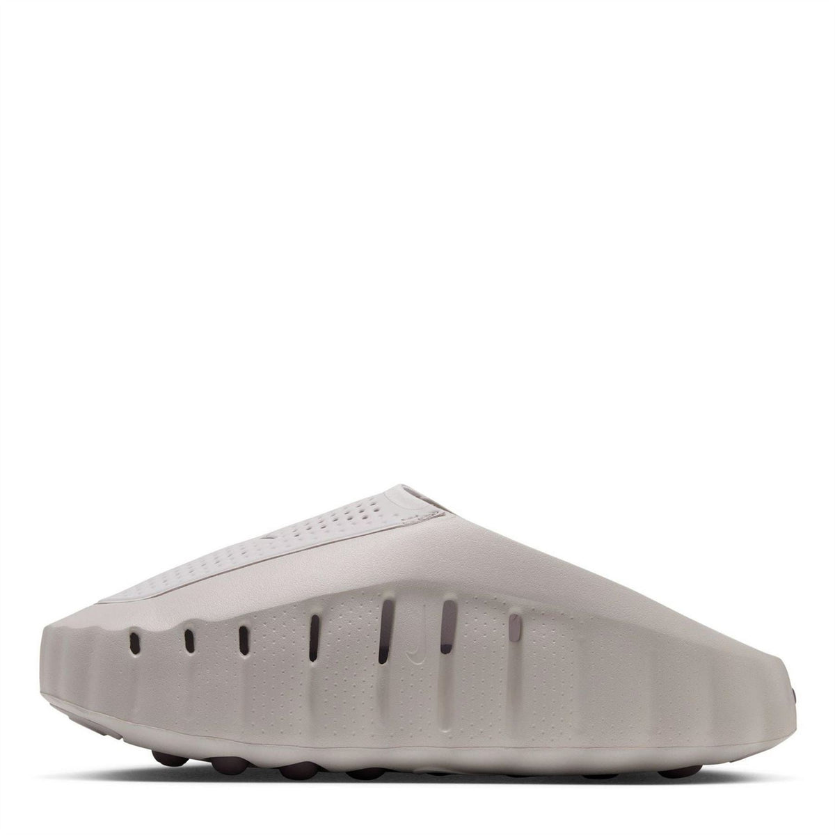 Light gray Nike slide sandals from side view with molded traction tread