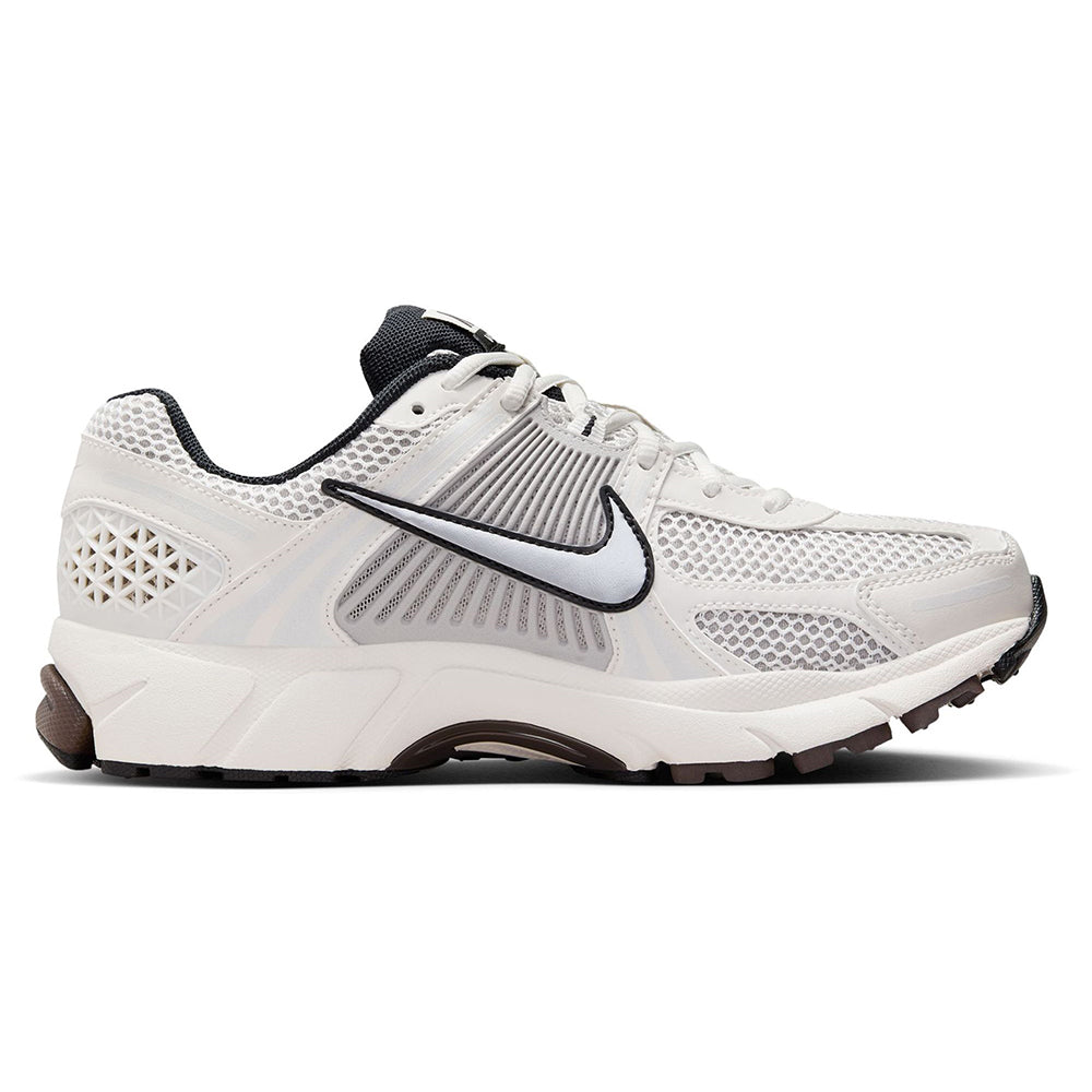 Women’s Nike running shoes side view in white with black swoosh and brown trim