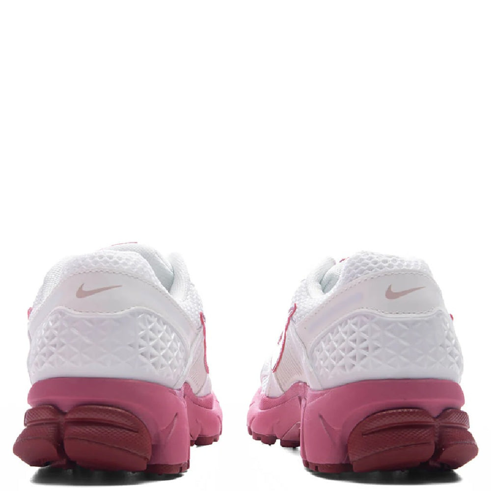 Women's Nike running shoe heel view, white back panel with magenta heel and outsole