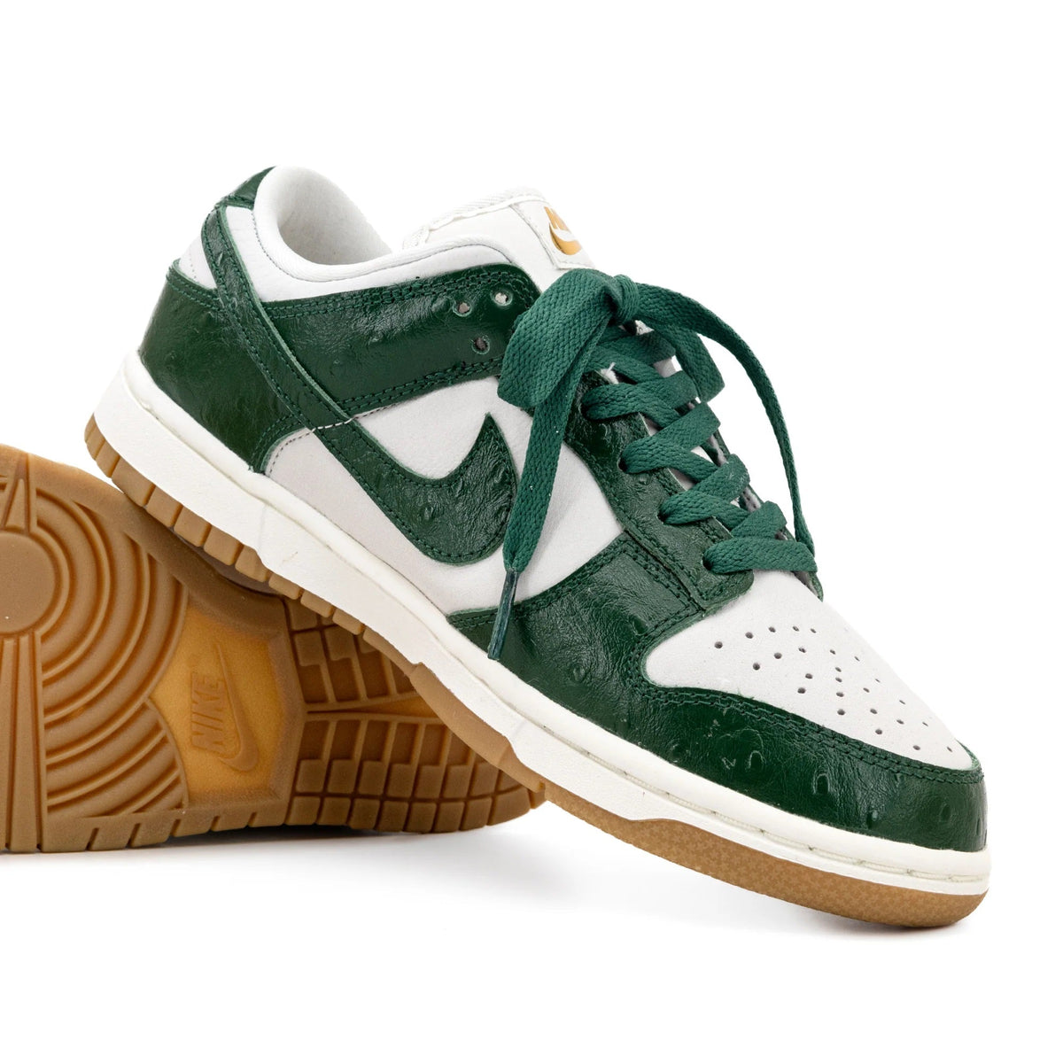 Women's low-top sneakers, white upper with dark green swoosh, green laces, gum sole.