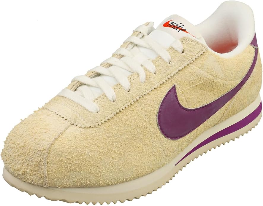 Women's Nike Cortez sneakers, tan suede upper with purple Swoosh and white lace trim.