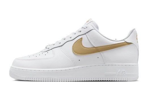 Nike low-top sneakers with white leather uppers and tan swoosh, lace-up design