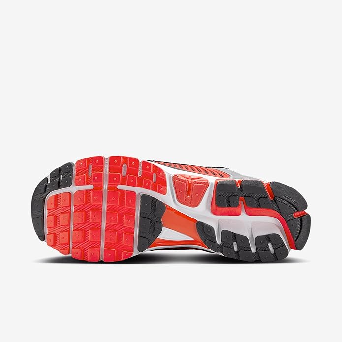 Nike Zoom Vomero 5 running shoe, outsole view, red traction pods on dark rubber