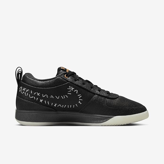 Black Nike low-top sneakers with patterned side panel and orange accent eyelets