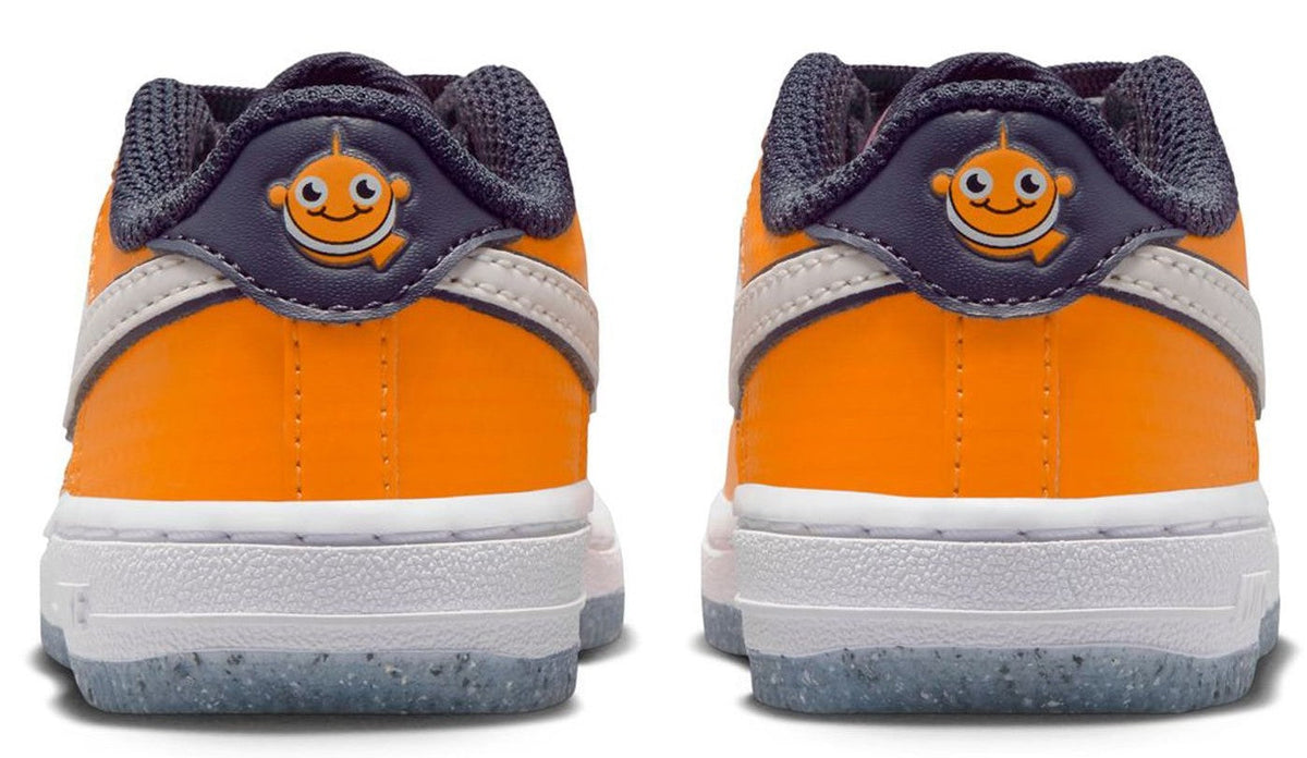Orange and white low-top sneakers with navy heel patch and smiley face logo
