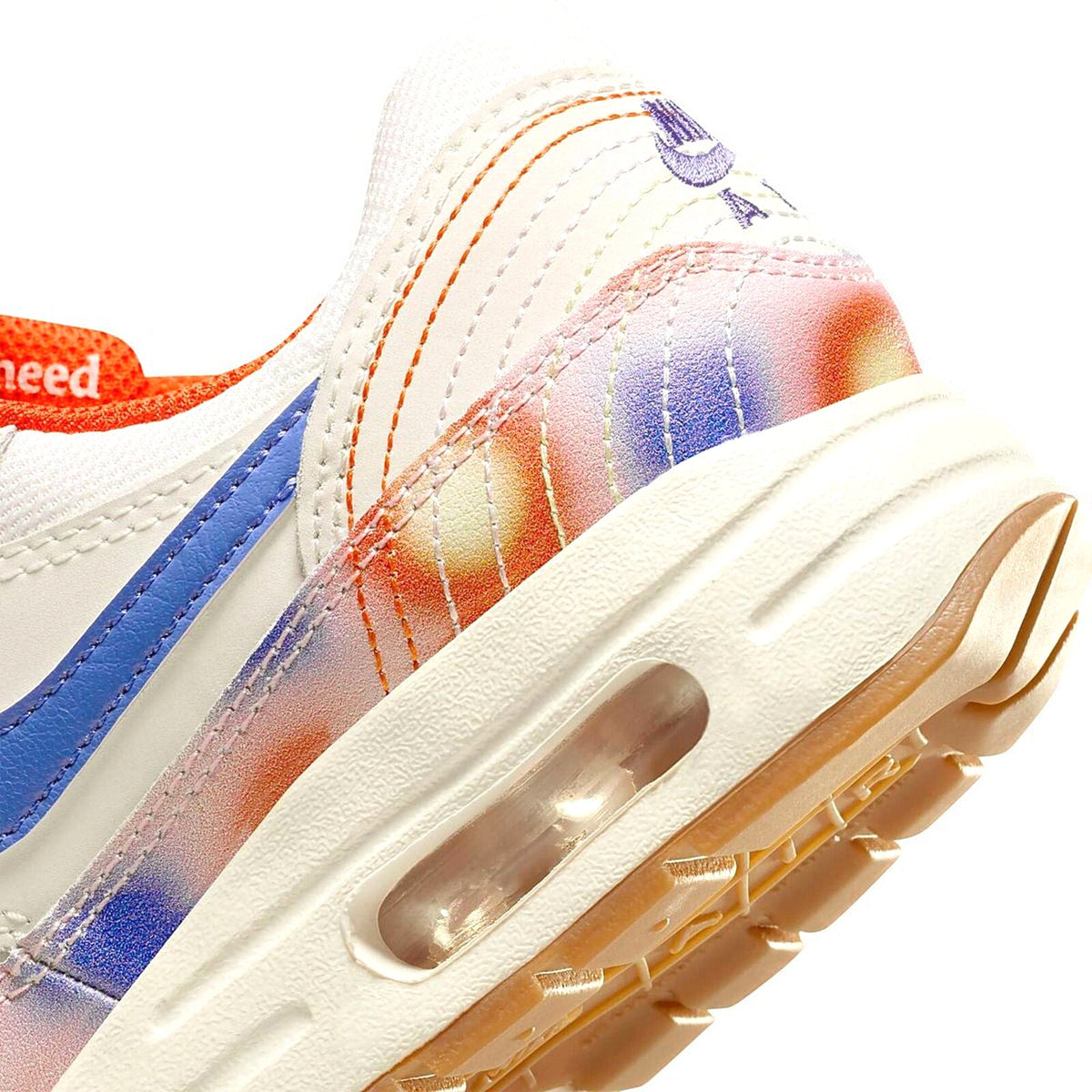 Kids' Nike Air Max 1 side panel close-up with rainbow gradient and blue swoosh