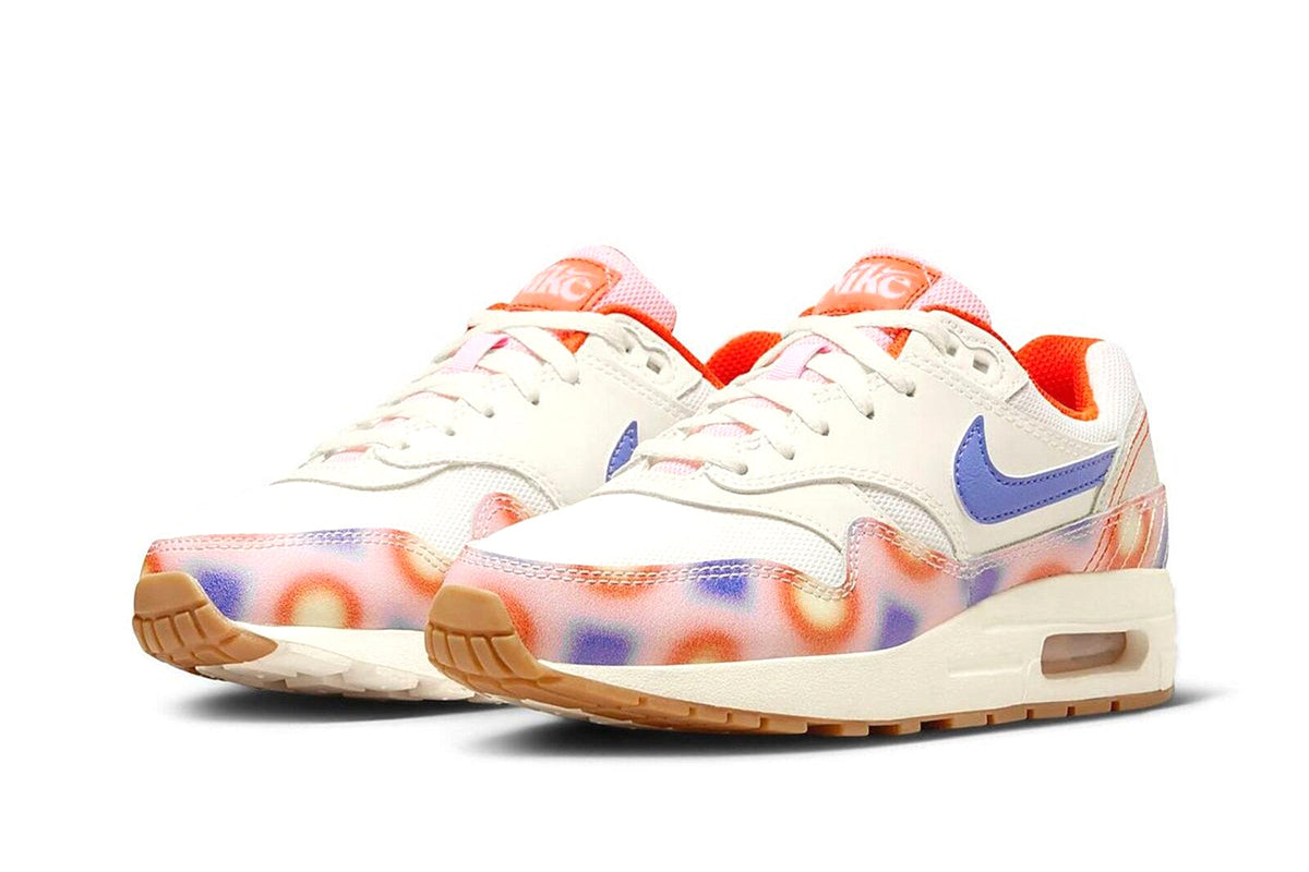 Kids' Nike Air Max 1 sneakers with white upper, blue swoosh, and orange laces