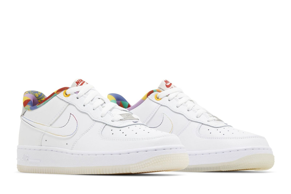 Pair of white kids Nike Air Force 1 low-top sneakers with multicolor laces and swooshes