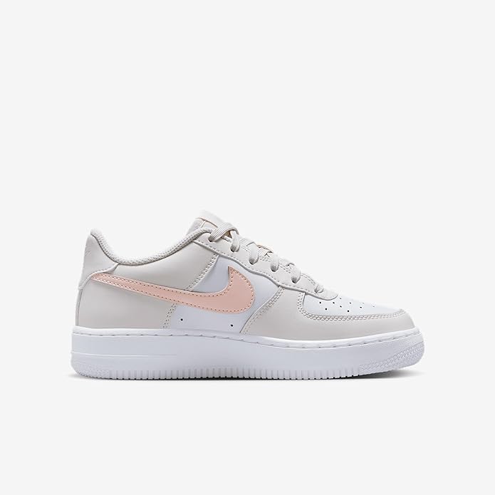 Big Kid's Nike Air Force 1 low sneakers, side view in white with pink swoosh