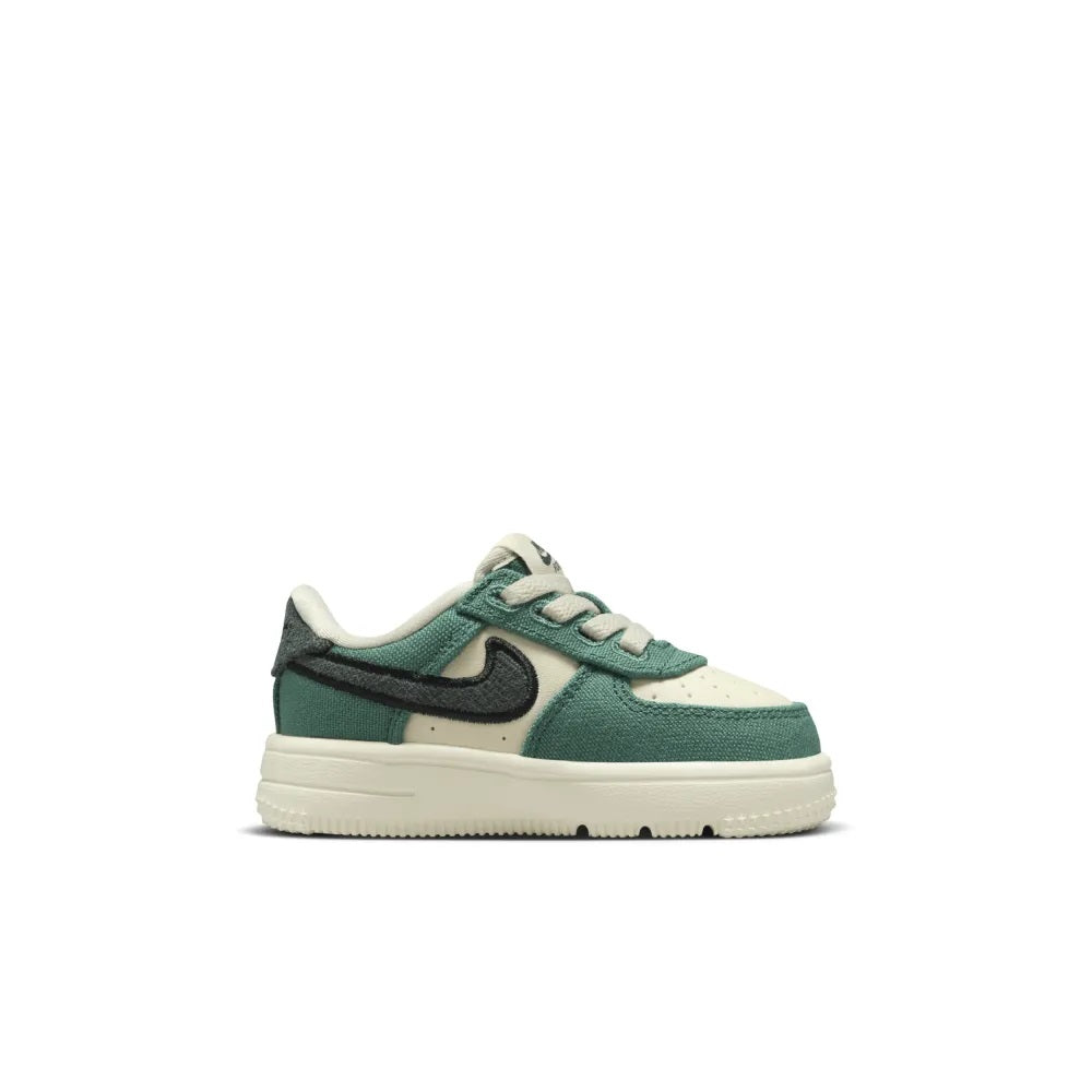 Toddler low-top lace sneaker with green heel panel, cream upper, and black Swoosh