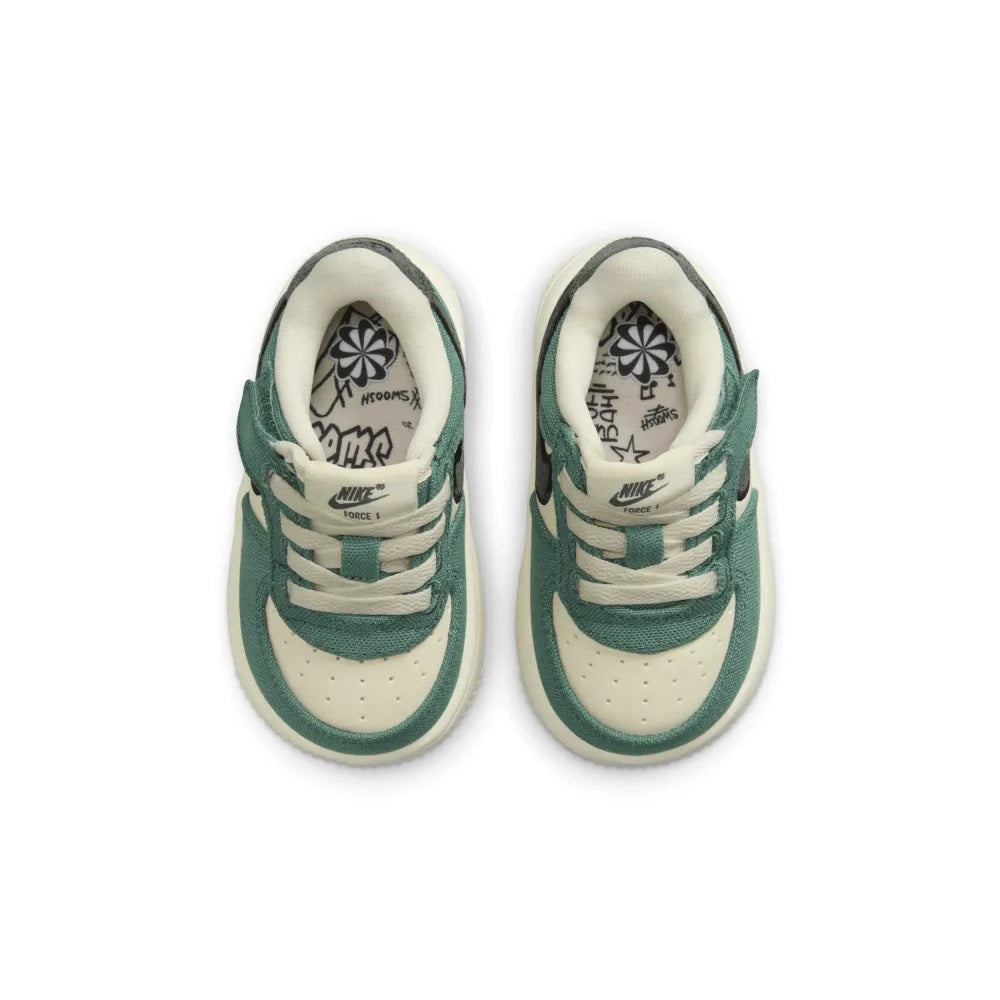 Pair of toddler sneakers with cream laces, green overlays, and Nike Swoosh