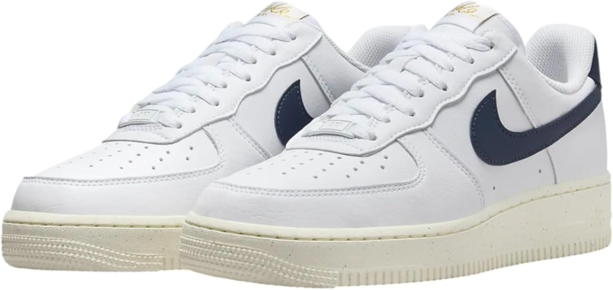 Pair of Nike Air Force 1 sneakers, white uppers with navy swooshes and cream soles