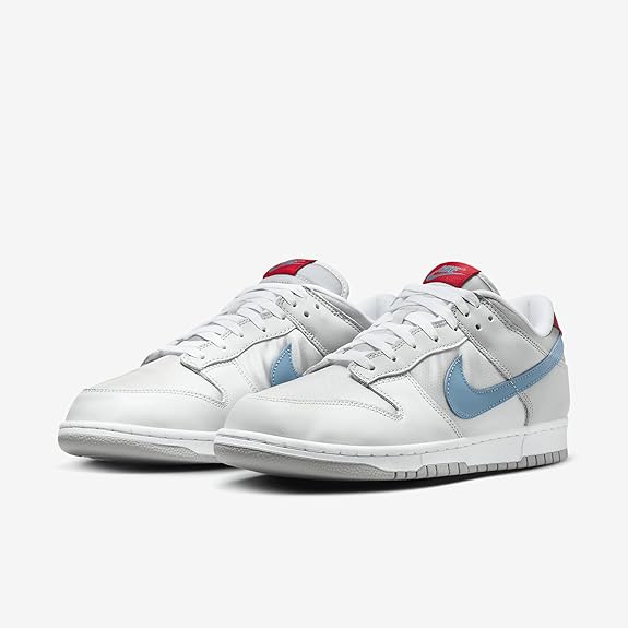 Nike Dunk Low QS sneakers, pair front angle in metallic silver with light blue accents.