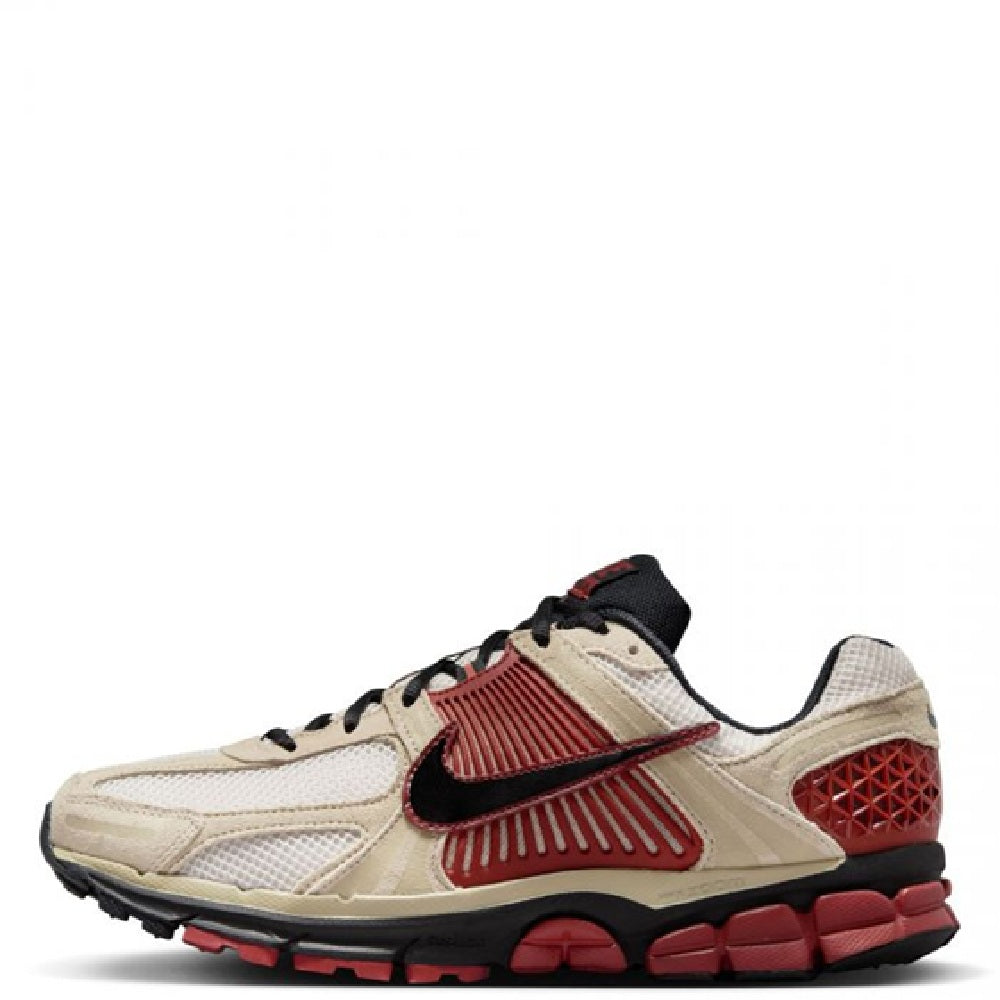 Nike Zoom Vomero 5 sneakers in light tan with red Swoosh, black laces, and black sole