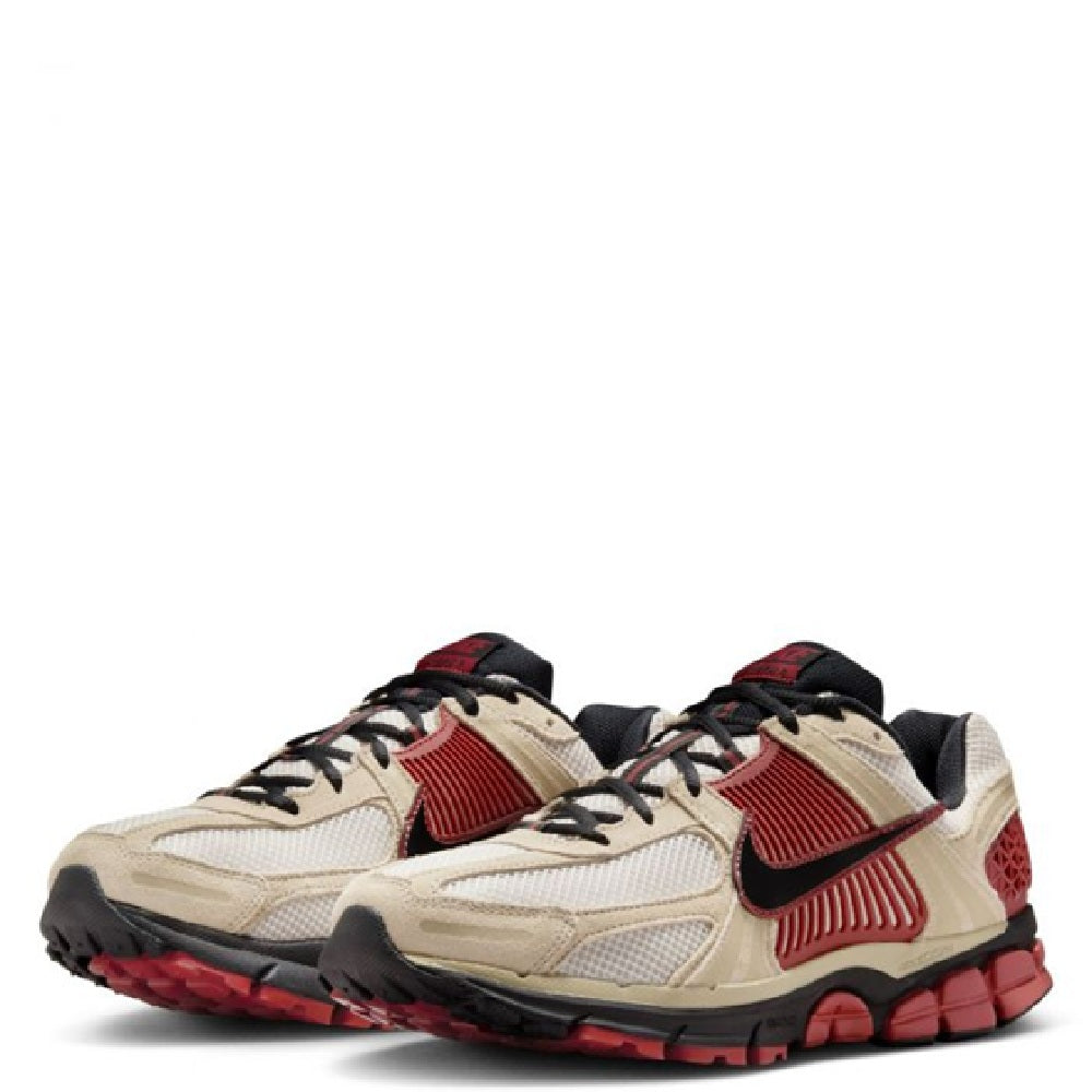 Nike Zoom Vomero 5 sneakers with light tan uppers, red Swoosh accents, and black laces