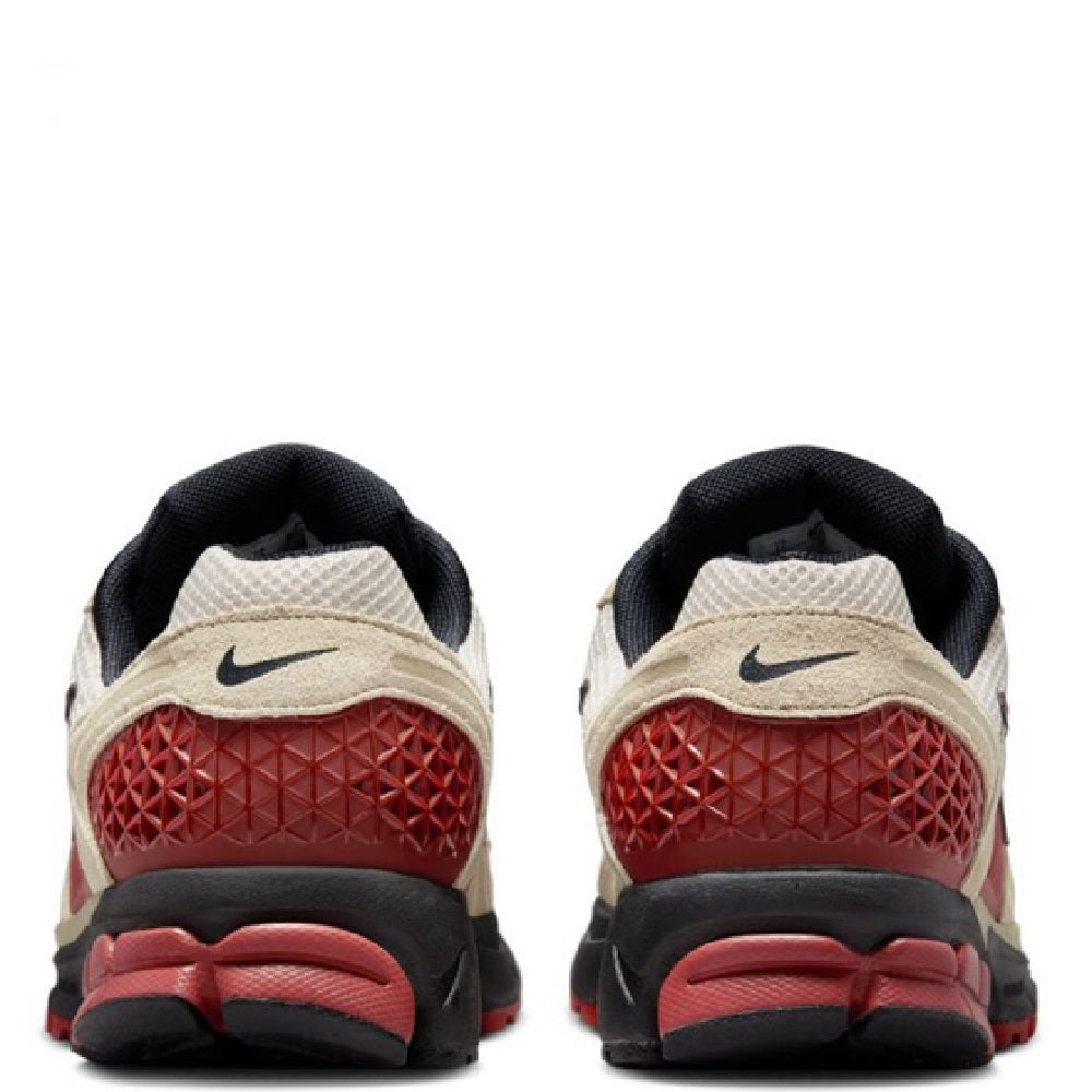 Nike Zoom Vomero 5 heel view with black collar, tan upper, red outsole detail, and Nike mark