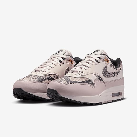 Light pink low-top sneakers pair with purple snake-print panels and visible Air unit