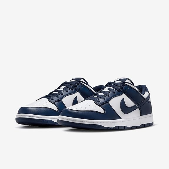 Nike Dunk Low sneakers showing navy and white uppers with lace eyelets and Swoosh