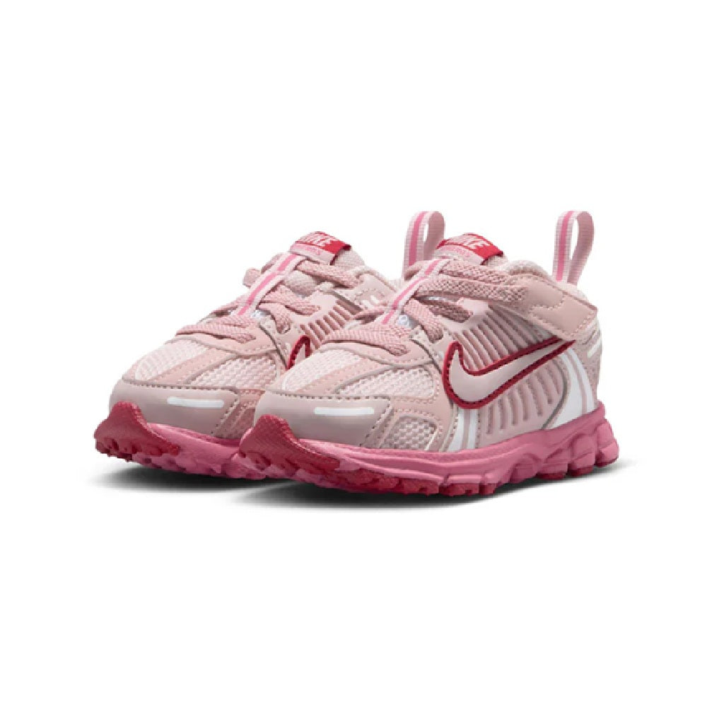 Toddler Nike Vomero 5 sneakers, light pink pair with red swoosh, textured straps, and laces.